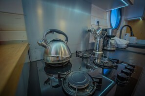 Eine Küche mit Wasserkocher, Herd und verschiedenen Küchenutensilien.