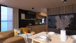 Ein modernes Interieur mit Essbereich, einer Couch und Blick aufs Meer.