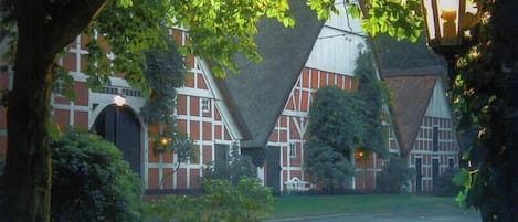 En traditionel bygning med en symmetrisk facade, store vinduer og en central indgang.