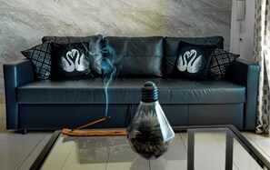 A living room with a sofa, decorative pillows, a glass table, and a smoke diffuser. - Las Americas Pool & Private Patio Apartment 7 (Playa de las Américas)