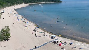 An aerial view of a beach with tents, umbrellas, and people. - Sunny 2BR Family Stay Near Beach and Canal (Port Colborne)