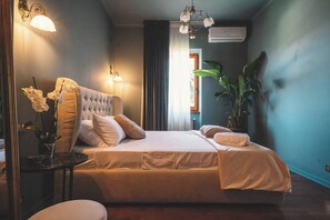 A bedroom with a large bed, bedside lamps, a potted plant, and a view of the outdoors. - Villa Elena - Luxury Mansion in Rome (Rome)