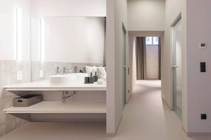 Ein modernes Badezimmer mit einem großen Waschbecken, einem Spiegel und Stauraumschränken.