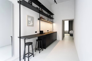 Eine moderne Küche mit Kochinsel, schwarzen Barhocker und minimalistischem Design.