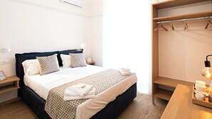 Ein Hotelzimmer mit Bett, Nachttischen, einem Kleiderschrank und einer Nachttischlampe.