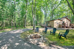 A lodge with a fire pit, outdoor seating, and a deck. - Cozy Bear Cabin / Trails, Firepit & Northern MI (Kalkaska)
