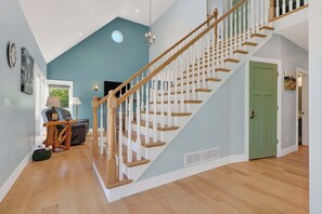 Eine Treppe mit Holzspindeln und einer grünen Tür am oberen Ende.