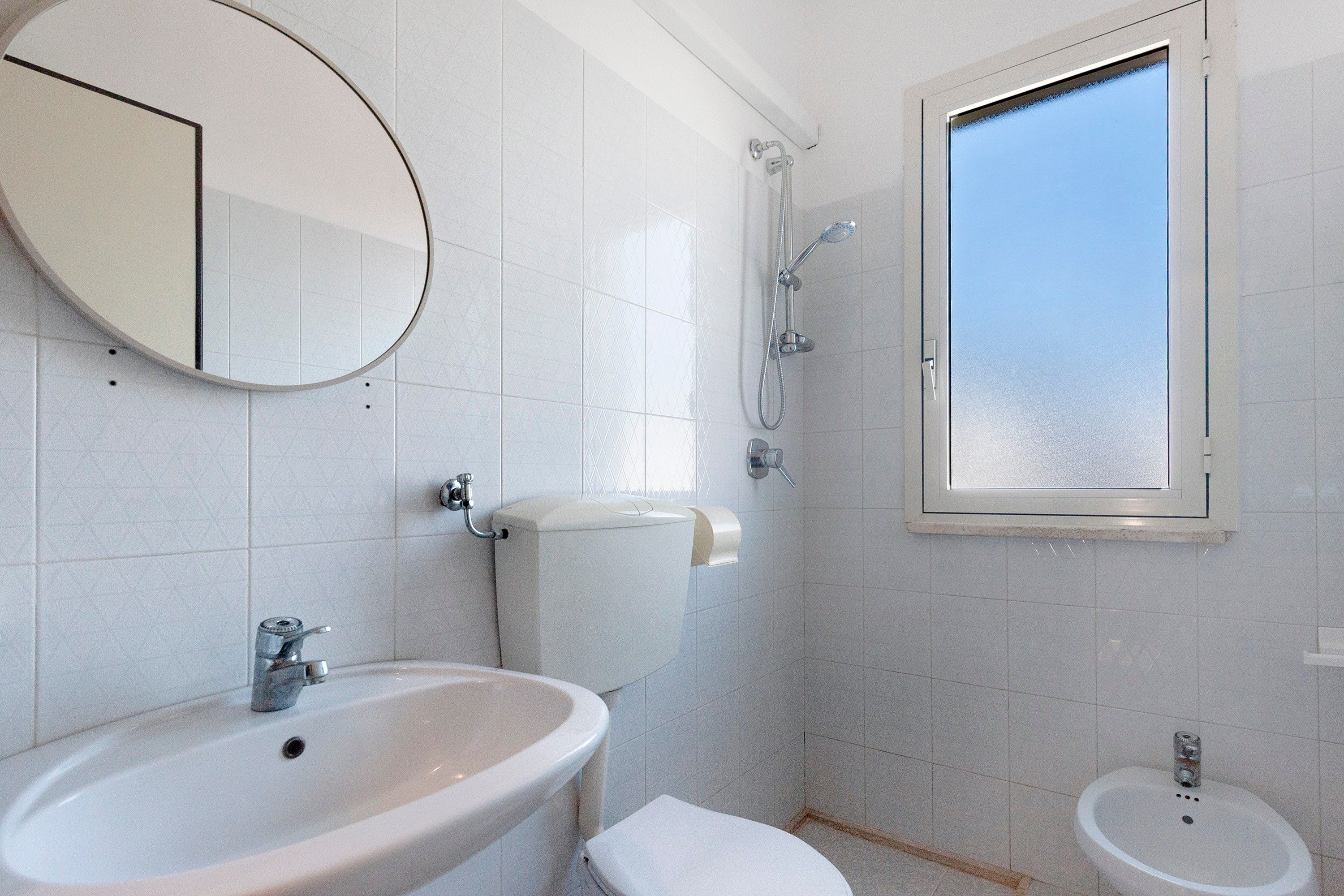 Une salle de bain équipée d’un lavabo, de toilettes, d’un bidet et d’une douche.