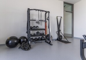 Et fitnessrum med vægttræningsstation, træningsbolde og en motionscykel.