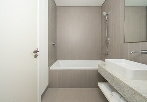 Ein modernes Badezimmer mit Badewanne, Waschbecken und Dusche.