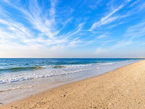 Una platja amb cel serè i onades tranquil·les.