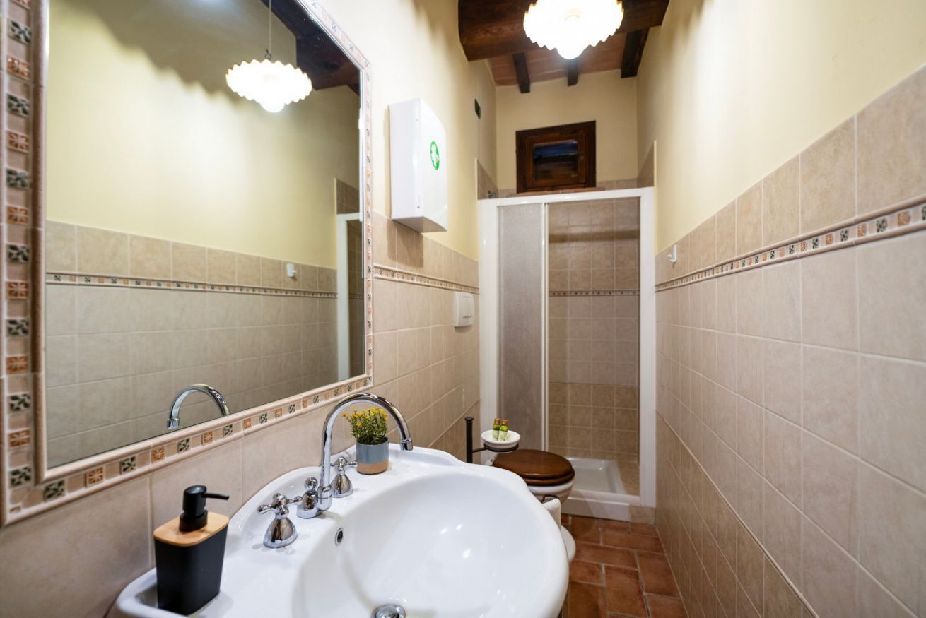 Ein Badezimmer mit Waschbecken, Spiegel, Dusche und Toilette.