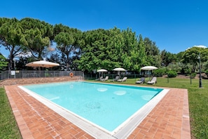 A rectangular swimming pool with a tiled border, surrounded by a grassy area and trees. - GuestHost - Il Casale dei Gelsi - Narciso (San Martino In Campo)