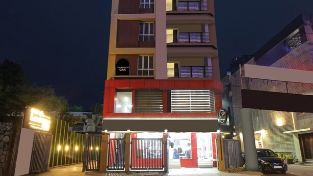 A multi-story building with a gated entrance, balconies, and a sign indicating 'Townhouse Oak.' - Townhouse Oak Hotel Lake View Royal (Kolkata)