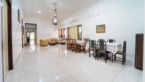 Amplia habitación con mesa de comedor, sillas, sofá y candelabro.