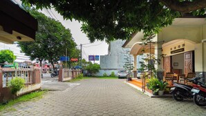 Una entrada pavimentada con una reja, un edificio con un cartel y motocicletas estacionadas.