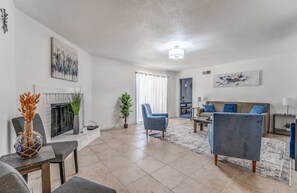 A living room with a fireplace, a sofa, a coffee table, and a blue armchair. - Near Dining, Shopping, Parks! Tranquil Fox Trails (Memphis)