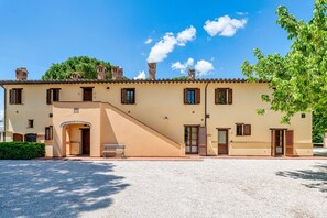 A building with a sloped roof, multiple windows, and a gravel driveway. - GuestHost - Il Casale dei Gelsi - Tulipano (San Martino In Campo)