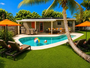 A modern house with a swimming pool, outdoor furniture, and a well-maintained lawn. - Private Oasis Near Beach - Heated Pool, Lounge, Bikes (Pompano Beach)