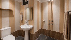 A modern bathroom with a toilet, sink, mirror, and shower. - Hotel Star City (New Delhi)