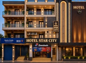 A multi-story hotel with balconies, a prominent sign for Hotel Star City, and a Domino's Pizza sign. - Hotel Star City (New Delhi)