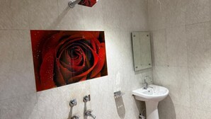 A bathroom with a large wall-mounted rose artwork, a sink, and a mirror. - Hotel Star City (New Delhi)