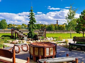 A park with wooden benches, a wooden gazebo, and a waterfall.