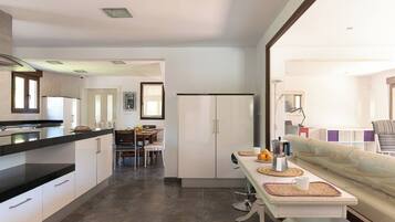 Una cocina moderna con comedor, un sofá y vistas al salón.