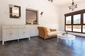 Ein Zimmer mit einem weißen Schrank, einem braunen Sofa, einem runden weißen Tisch und einem großen Fenster mit Blick.
