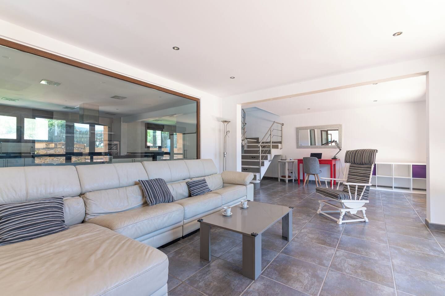 Una sala moderna con sofá, mesa de centro y comedor con escritorio y silla.