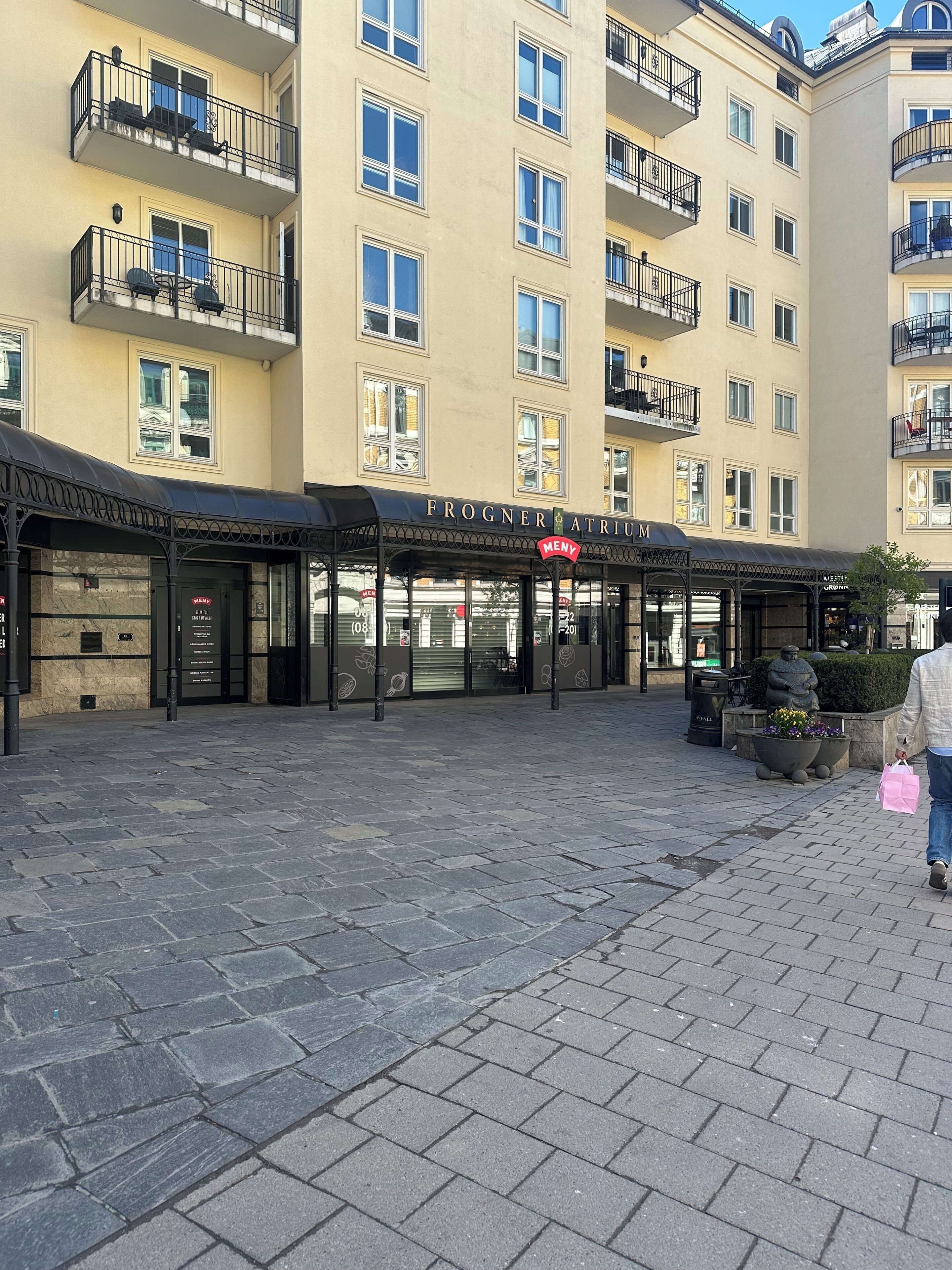Un edificio con entrada cubierta, varios balcones y un cartel que dice 'FROGNER ATRIUM'.