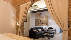 Une chambre à coucher comprenant un lit, un canapé, une table basse et un coin repas avec une table et des chaises.
