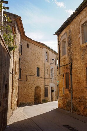 A narrow street with stone buildings, a paved road, and a street lamp. - Can Joan Loft - A romantic loft with a medieval arch on the Costa Brava (Ordis)