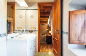 A bathroom with a sink, mirror, and wooden door. - Country House with Vineyard Views, BBQ & Fireplace (El Pla del Penedès)