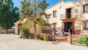 A two-story building with a balcony, a sign with 'A&S' on the front, and a tree in the foreground. - Vineyard-View Country House with BBQ & Fireplace (El Pla del Penedès)