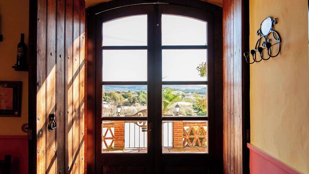 A wooden door with a view of a balcony and landscape. - Vineyard-View Country House with BBQ & Fireplace (El Pla del Penedès)