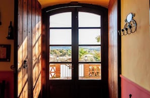 A wooden door with a view of a balcony and landscape. - Country House with Vineyard Views, BBQ & Fireplace (El Pla del Penedès)