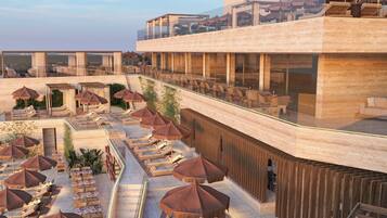 Un bar situé sur le toit, avec une terrasse et des parasols.