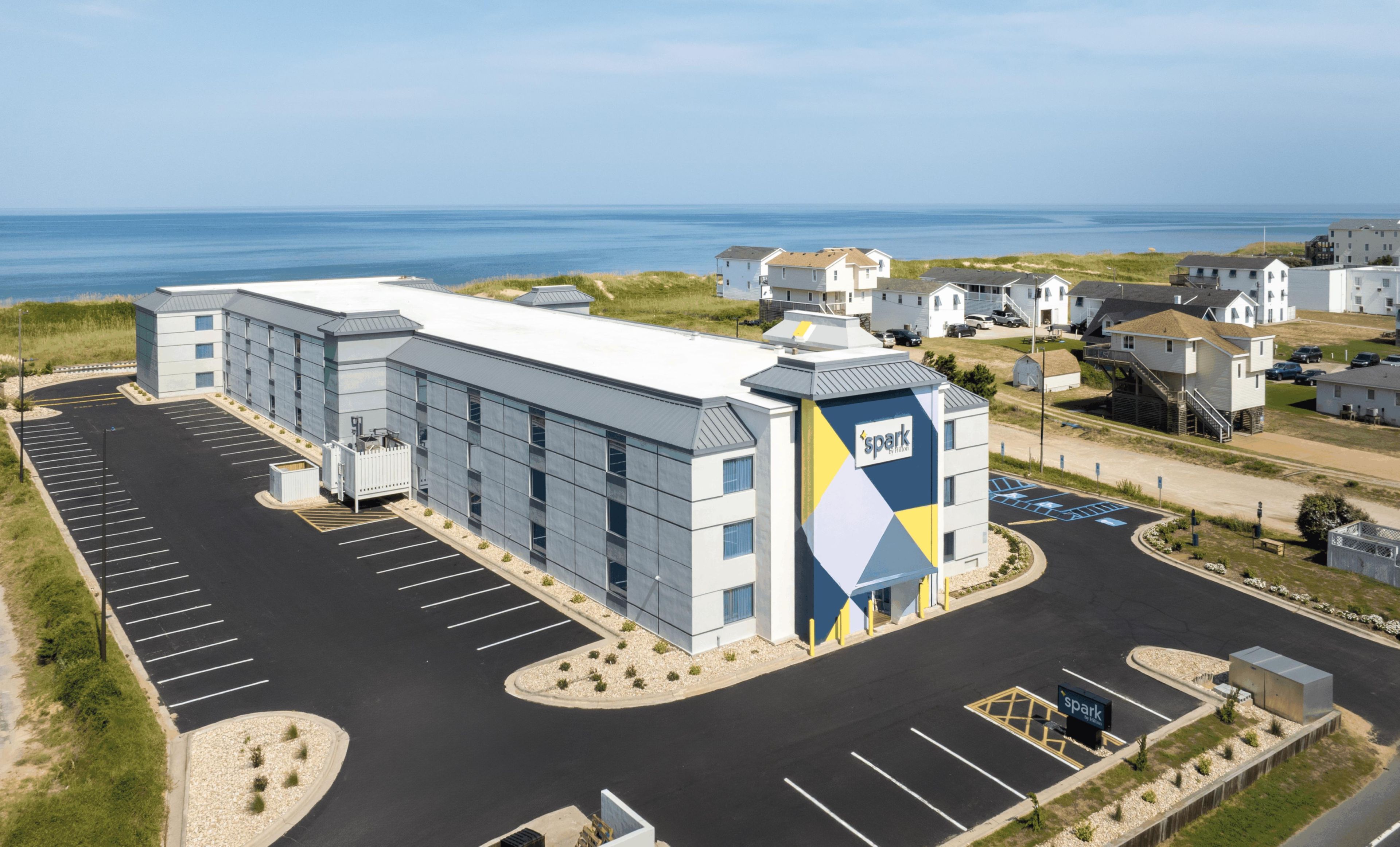 Un bâtiment moderne doté d’un parking et offrant une vue sur l’océan.