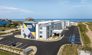 Un hotel con estacionamiento y vistas al mar.