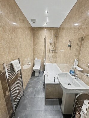 A modern bathroom with a bathtub, a sink, a toilet, and a towel rack. - 2 Bed Flat in Central Edinburgh (Edinburgh)