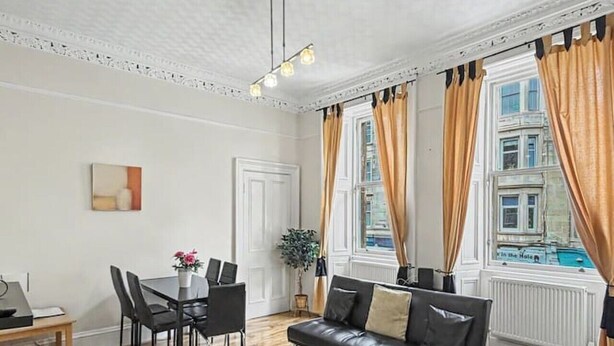 Un salon moderne avec un canapé, une table basse et un coin repas.