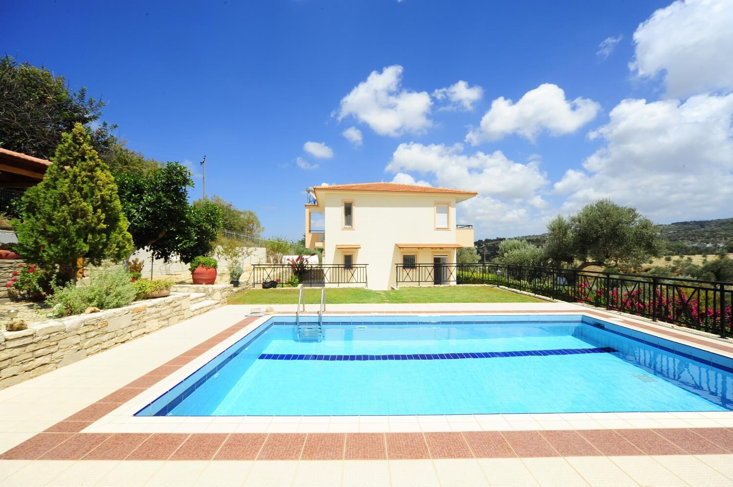Une maison à deux étages avec une piscine en premier plan.