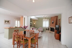 Ein modernes Wohnzimmer mit Essbereich, Kamin und Fernseher.