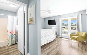 Ein Schlafzimmer mit Bett, Fernseher, Sessel und Fenster mit Blick.