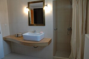 Ein Badezimmer mit Waschbecken, Spiegel und Dusche.