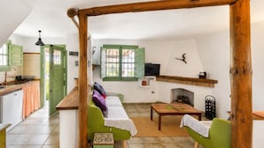 Ein gemütliches Wohnzimmer mit einer Couch, einem kleinen Tisch und einem Kamin.