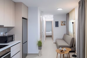 Eine moderne Küche mit Mikrowelle, Kühlschrank und einer kleinen Essecke mit Tisch und Stühlen.