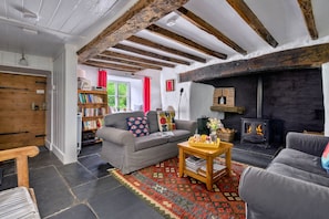 Ein gemütliches Wohnzimmer mit Kamin, einer Couch, einem Couchtisch und einem Bücherregal.