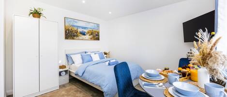 Une chambre à coucher moderne avec un lit, une table de chevet et un tableau au mur.